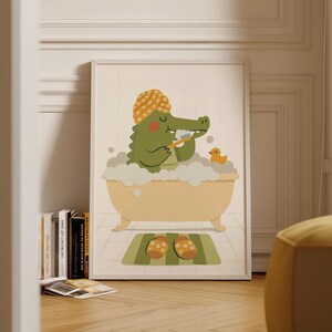May include: A framed illustration depicts a green alligator in a yellow bathtub, wearing a turban and brushing its teeth. A rubber duck and a pair of floral slippers on a green bath mat complete the scene. The artwork is set against a tiled background.