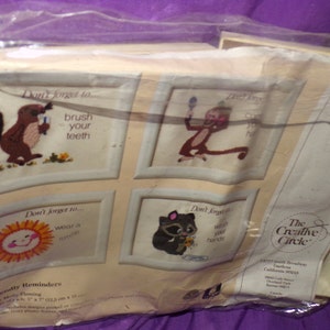 May include: A set of four embroidery kits featuring whimsical animal illustrations and reminders to brush your teeth, wear a sweater, and hold hands. The kits are packaged in a clear plastic bag with a white background and the text "The Creative Circle" and "4004".