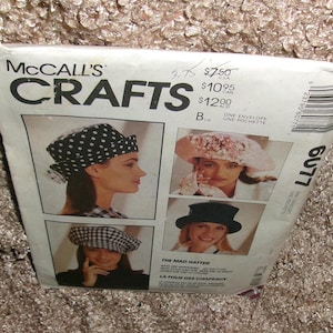 May include: A McCall's Crafts sewing pattern envelope for hats, numbered 6077. The white paper envelope features photographs of three different hat styles, including a polka dot hat, a floral hat, and a solid dark hat, with text.