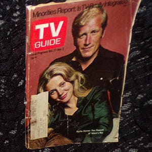 May include: A vintage TV Guide magazine cover featuring Blythe Danner and Ken Howard. The cover has a red background with the magazine's logo and the text "Minorities Report: Is TV Really Integrated." The cover also includes the text "Local Programs Oct. 27-Nov. 2" and the price "15¢".