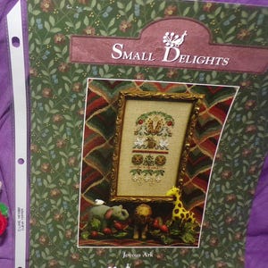 May include: A cross-stitch pattern for a Joyous Ark design by Just-Nan. The pattern features a colorful ark with animals and a floral border. The pattern is part of the Small Delights collection.