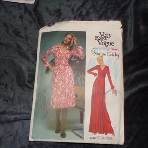 May include: Vintage Very Easy Vogue sewing pattern featuring a wrap dress with a red and white pattern. The pattern includes a long-sleeved dress design with a V-neckline. The pattern number is 1549.