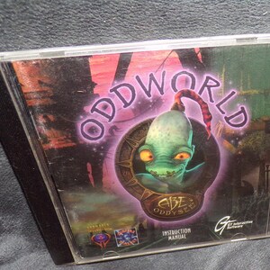 May include: Abe's Oddysee PC game in a clear plastic case. The cover features a green alien with orange eyes and the word "ODDWORLD" in purple. The game's title is "ABE ODYSSEE" with the GT Interactive Software logo.