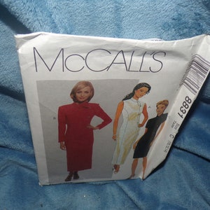 May include: McCall's sewing pattern number 8881 for a dress. The pattern shows three different styles of dresses, one red, one white, and one black.