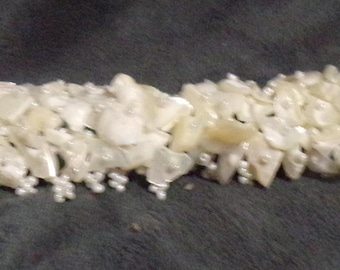 Pulsera tejida elástica de cuentas blancas con cuentas de semillas y conchas