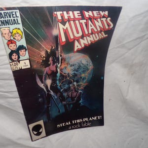 May include: A vintage comic book cover for "The New Mutants Annual" from Marvel Comics. The cover features a dynamic illustration of characters with a space and planet theme. The comic is marked with the Marvel logo, the price of $1.00, and the year 1984.