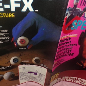 May include: An advertisement for "EYE-FX MOTION PICTURE EYES!" featuring a hand with blue skin holding a realistic eye. The magazine cover on the right features Patrick Stewart. The text reads "The Art of TOTAL STAR TREK SPECTACULAR."