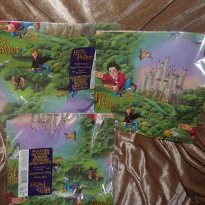 May include: Three packages of Harry Potter gift wrap featuring a green forest landscape, Hogwarts castle, and characters flying on broomsticks. Each package includes two sheets measuring 20 inches by 30 inches, with the Harry Potter logo printed on the front.