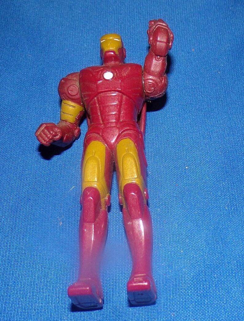 May include: Red and gold plastic action figure of Iron Man with a raised right arm.