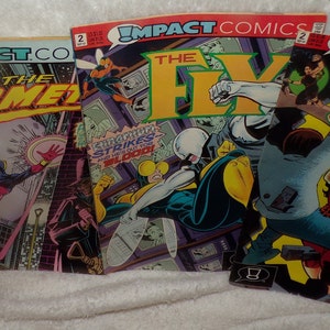 May include: Three comic books with colorful covers featuring superheroes. The first comic book is titled "The Comedian" and features a red superhero with a yellow mask. The second comic book is titled "The Fly" and features a white and yellow superhero with a black mask. The third comic book is titled "The Jackal" and features a woman in a red and black costume.