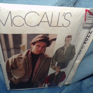 May include: McCall's sewing pattern for a men's jacket. The pattern is for size 38 and is shown on a model wearing a brown jacket with a plaid scarf. The pattern also includes a second jacket style.