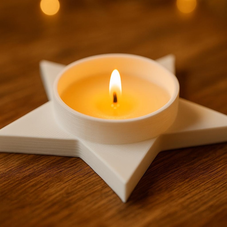 May include: A lit candle in a white holder shaped like a star. The candle is round and filled with yellow wax, with a bright flame. The star-shaped holder is white and sits on a wooden surface.