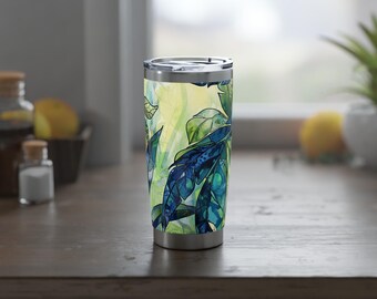 Op de afbeelding: Een roestvrijstalen beker met een blauw en groen bladmotief. De beker heeft een zilveren deksel en een zilveren bodem.