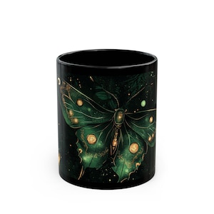 May include: Black ceramic mug with a green and gold butterfly design. The butterfly has a starry pattern on its wings.