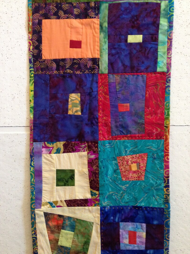 Puede incluir: Una colcha de retazos colorida con una variedad de telas y patrones. La colcha est&aacute; hecha de cuadrados y rect&aacute;ngulos, y los colores incluyen morado, azul, verde, rojo, naranja y blanco.
