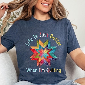 Peut inclure: Un t-shirt bleu marine avec un motif d'étoile en patchwork coloré et le texte "Life is Just Better When I'm Quilting".