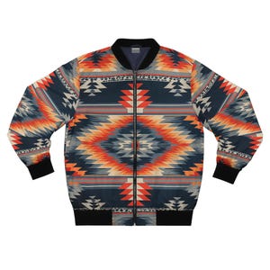 Puede incluir: Chaqueta bomber con un patrón geométrico de inspiración suroeste. La chaqueta presenta una base azul marino con diseños de diamantes y flechas en naranja, gris y blanco. Tiene cuello, puños y dobladillo negros, y una cremallera completa.