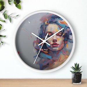Może przedstawiać: Biały zegar ścienny z kolorowym abstrakcyjnym obrazem twarzy kobiety. Obraz zawiera odcienie niebieskiego, fioletowego, żółtego i czerwonego.