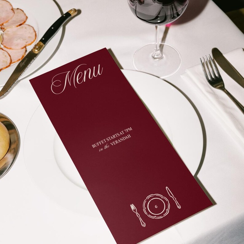 Pode incluir: Um cart&atilde;o de menu bord&ocirc; com a palavra "Menu" em escrita elegante. O cart&atilde;o inclui o texto "BUFFET STARTS AT 7PM in the Verandah" e um gr&aacute;fico de um prato, garfo e faca. Um copo de vinho e talheres tamb&eacute;m s&atilde;o vis&iacute;veis.