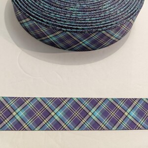 May include: A roll of purple, blue, and white plaid ribbon. The ribbon has a checkered pattern.