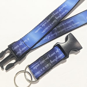 May include: A blue and black lanyard with a silver key ring. The lanyard has the text "To everything there is a season, a time for every purpose under heaven" printed on it.