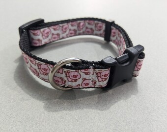 May include: A white dog collar with a pink pig pattern and a black buckle.