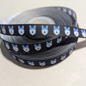 May include: Black ribbon with a repeating pattern of blue wolf faces.