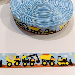 May include: Blue and white ribbon with a repeating pattern of yellow construction vehicles on a white background. The vehicles include a dump truck, a bulldozer, and a forklift.