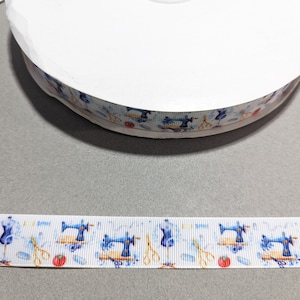 May include: White satin ribbon with a repeating pattern of blue sewing machines, red apples, scissors, and spools of thread.