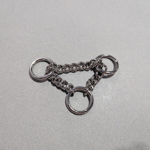 May include: A silver chain with three attached rings, forming a triangular shape.