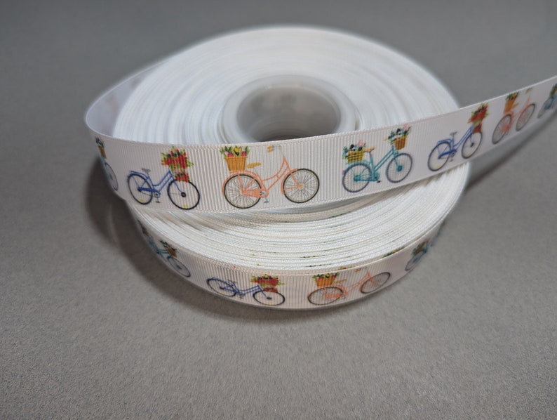 May include: White ribbon with a repeating pattern of colorful bicycles with baskets of flowers.