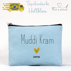 Könnte beinhalten: Eine hellblaue Reißverschlusstasche mit dem Text "Muddi Kram" und dem Namen "Sophia" unter einem gelben Herz. Die Tasche hat einen schwarzen Reißverschluss und die Worte "Taschenfarbe Hellblau" stehen darüber.