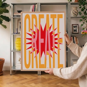 Peut inclure: Une affiche encadrée rectangulaire présentant le mot CREATE en grandes lettres orange sans empattement. Un graphique en forme d'étoile rouge et rose vif est superposé derrière le texte, centré sur un fond blanc uni.