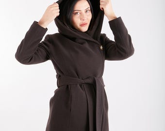 May include: A brown hooded wrap coat with a belt and a single button closure. The coat is made of a soft, warm fabric and has a relaxed fit.