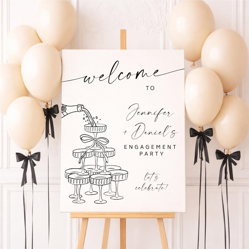 May include: A white engagement party sign on an easel, with the words "welcome to Jennifer + Daniel's Engagement Party" in black script. Champagne glasses are illustrated below the text. Cream-colored balloons and black bows decorate the scene.
