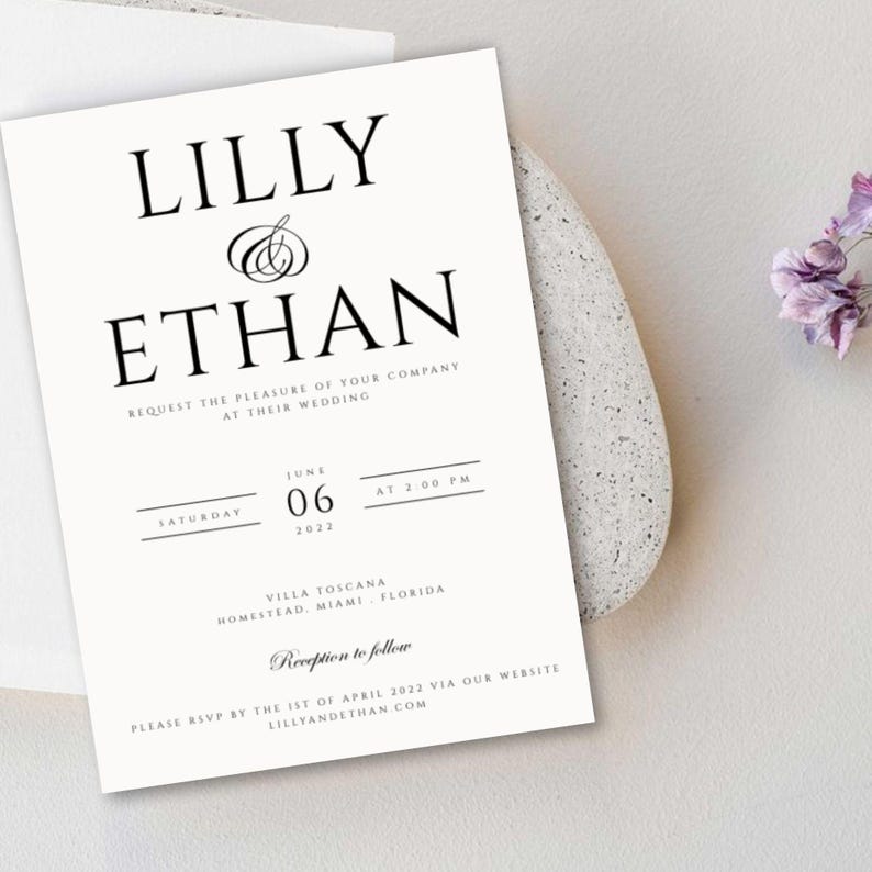 May include: A white wedding invitation with black text. The invitation reads "Lilly & Ethan" and includes the date, time, and location of the wedding. It also includes the text "Reception to follow" and instructions for RSVP.