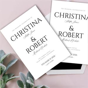 Könnte beinhalten: Zwei weiße Hochzeitseinladungskarten mit schwarzem Text. Die obere Karte lautet "The Wedding Celebration of Christina & Robert" mit den Namen des Paares in kursiver Schrift darunter. Die untere Karte lautet "The Wedding Celebration of Christina & Robert" mit den Namen des Paares in kursiver Schrift darunter. Beide Karten enthalten das Datum und den Ort der Hochzeit.