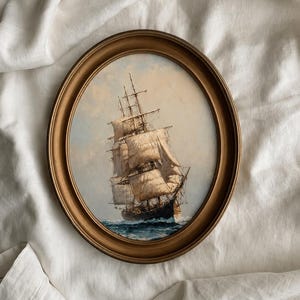May include: An oval-shaped painting in a gold-toned frame depicting a tall ship with white sails navigating through choppy blue ocean waves under a soft, cloudy sky. The artwork captures the vessel in motion, highlighting the detailed rigging.