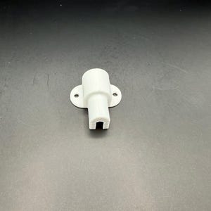 May include: White plastic wall mount with two holes for mounting and a slot for a cable or wire.