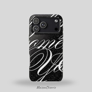 Könnte beinhalten: Schwarze Handyhülle mit weißem Schreibschrifttext und einem gesprenkelten Design. Die Hülle hat ein Kameramodul mit drei Objektiven. Der Text lautet "Come & Do". Der Markenname "Maison Cherrie" steht unten.