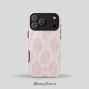 Puede incluir: Funda de teléfono rosa con un estampado floral blanco y las iniciales "SB". La funda tiene un módulo de cámara negro y detalles negros en los laterales. La marca "MaisonCherrie" está impresa en la parte inferior.