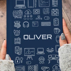 Peut inclure: Un cahier bleu marine avec des illustrations en trait blanc d'icônes liées à la technologie, notamment des ordinateurs portables, des écouteurs et un drone. Le nom "OLIVER" est imprimé en blanc. Une tasse de café et une bougie allumée sont en arrière-plan.