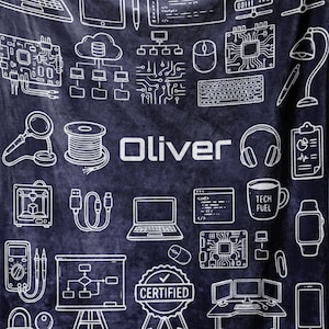May include: A navy blue blanket with white line drawings of tech-related icons, including laptops, servers, and a coffee mug that says "TECH FUEL." The name "Oliver" is printed in white. The blanket is held up by a person.