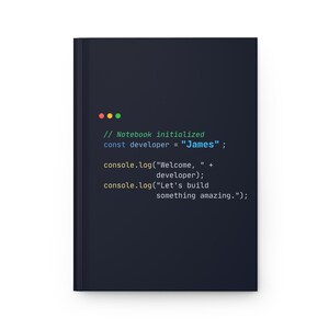 Puede incluir: Un cuaderno negro con texto blanco que dice "// Notebook initialized const developer = James; console.log("Welcome, " + developer); console.log("Let's build something amazing.")". El cuaderno tiene un dise&ntilde;o sencillo.