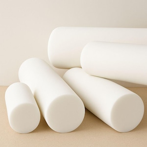 May include: A collection of white foam rollers in different sizes. The cylindrical shapes have rounded ends and are arranged on a neutral surface. These are likely used for exercise or physiotherapy, with measurements in cm.