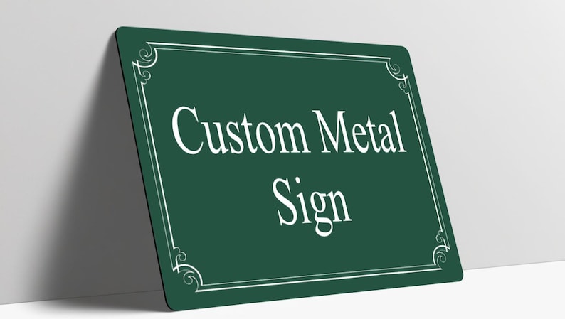 May include: A rectangular dark green metal sign with rounded corners. The sign features a white border with decorative corner flourishes and the white text Custom Metal Sign centered on the front surface of the flat metal plate.