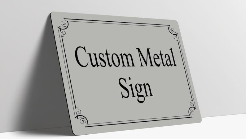 May include: A rectangular light gray metal sign with rounded corners, featuring a black decorative border and the black text Custom Metal Sign centered on the surface. The sign is positioned at an angle against a plain white background.
