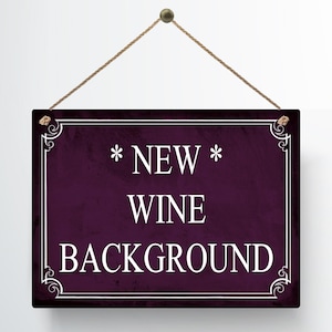 May include: A rectangular sign with a dark purple background and white text that reads "* NEW * WINE BACKGROUND". The sign is framed with a white border and decorative corner elements. It hangs from a brown string.