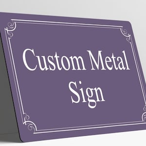 May include: A rectangular purple metal sign with rounded corners featuring a white border with decorative corner flourishes. The text Custom Metal Sign is printed in the center in a white serif font. The sign is positioned at an angle.