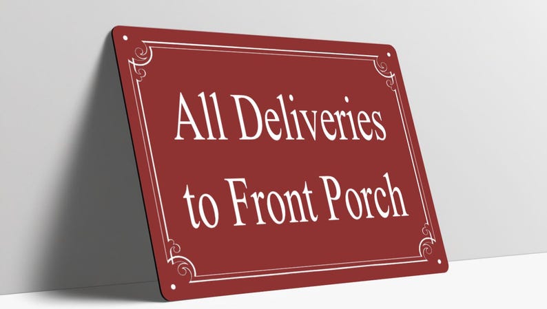 May include: A rectangular maroon metal sign with rounded corners and four small mounting holes. The sign features a white border with decorative corner flourishes and the white text All Deliveries to Front Porch centered on the face.